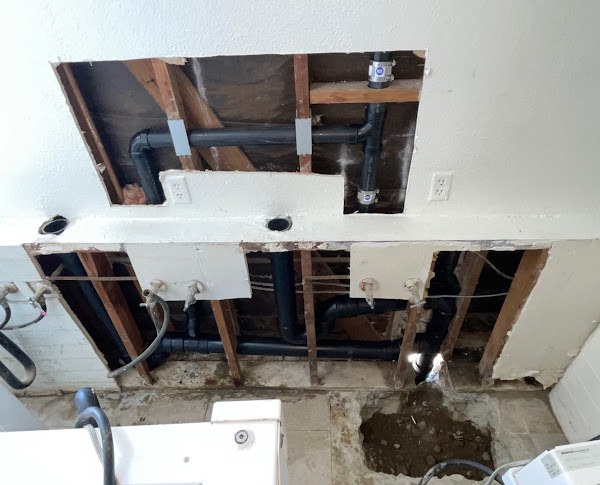 Whole-home repiping with new drain lines exposed in the wall and slab